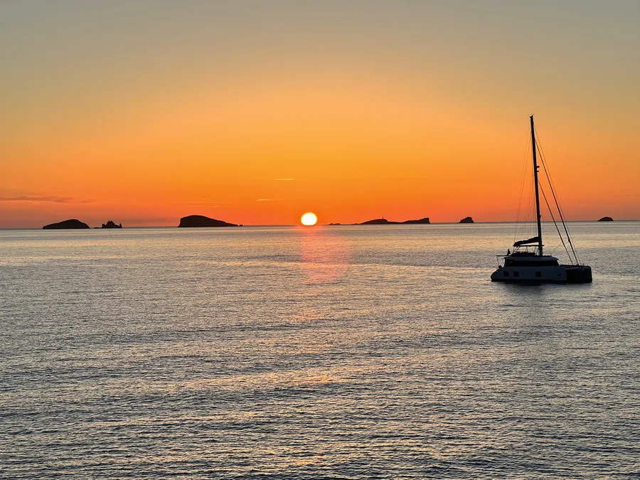 Sunset over the sea with a catamaran, Ibiza west coast